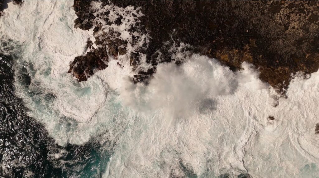 Foto aérea de olas rompiendo contra los acantilados de lava de Las Islas Canarias